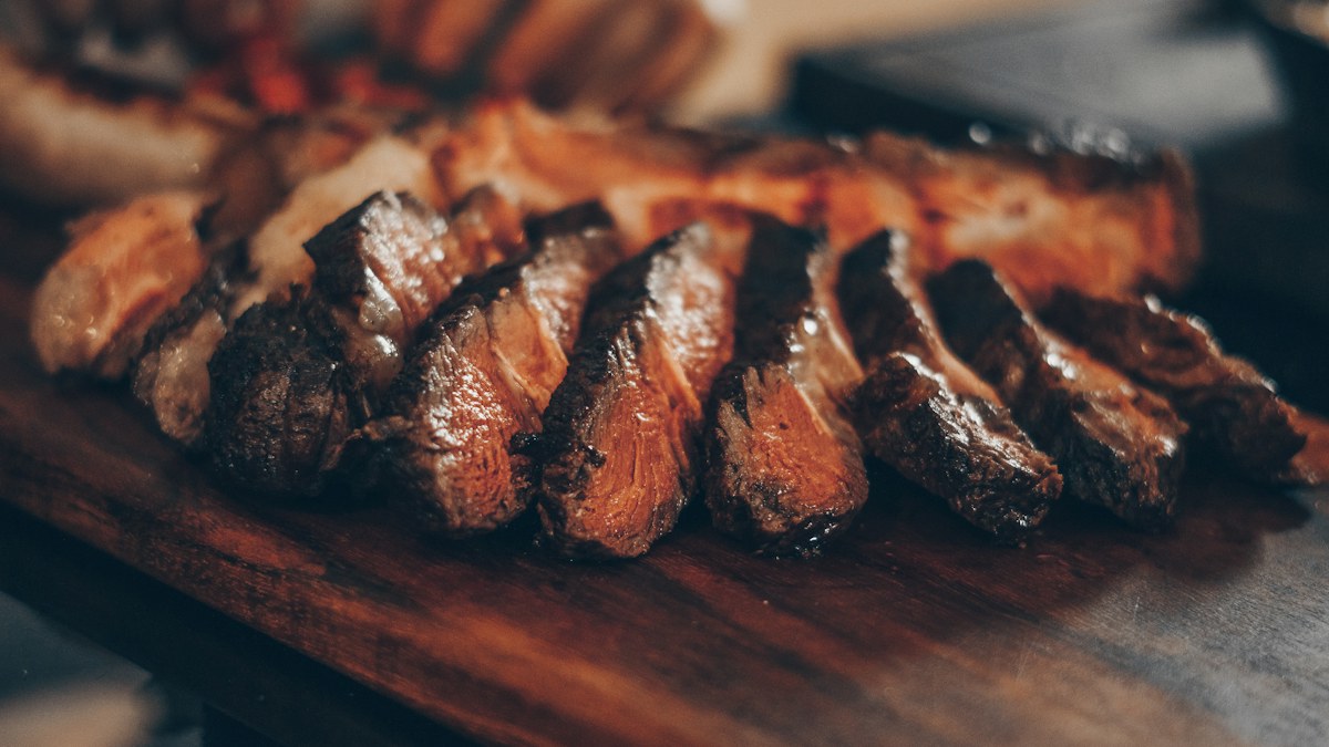 Corte de carne con guarnición en un plato oscuro